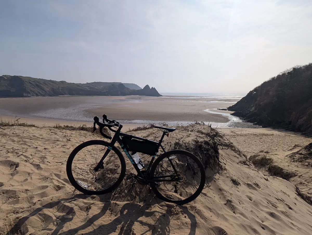 A bike on sand dunes above a wide bay